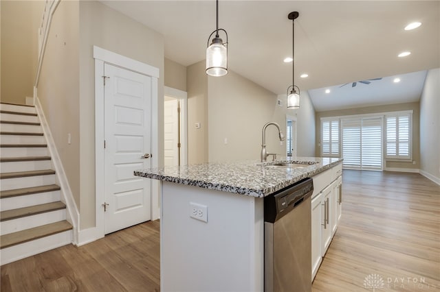 kitchen with white cabinetry, sink, stainless steel dishwasher, an island with sink, and pendant lighting