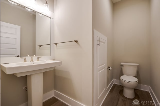 bathroom featuring hardwood / wood-style flooring and toilet