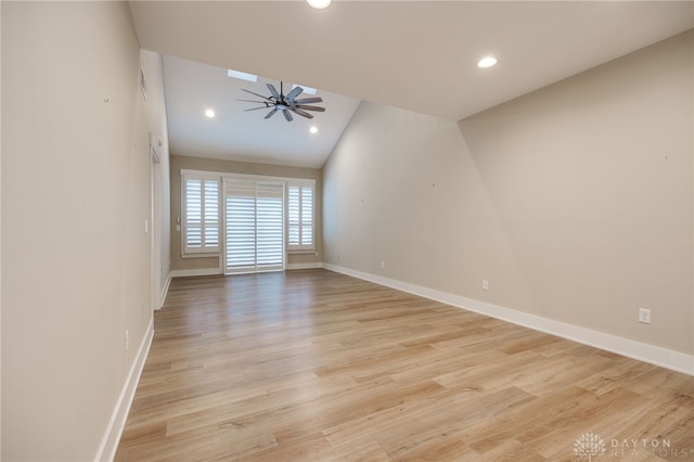 unfurnished room with ceiling fan, lofted ceiling, and light wood-type flooring