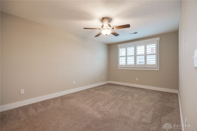 carpeted empty room featuring ceiling fan and a textured ceiling