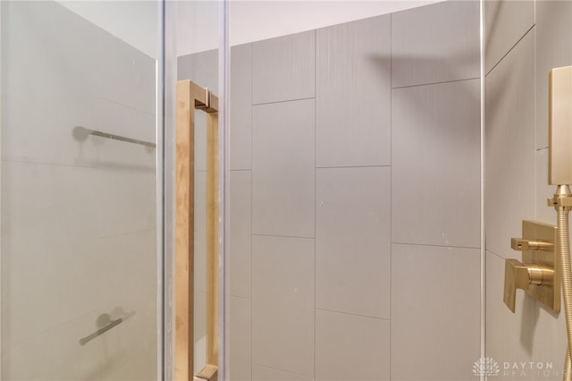 bathroom with a shower with door