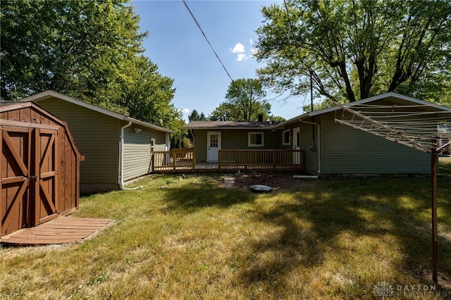 rear view of house featuring a shed, a yard, and a wooden deck