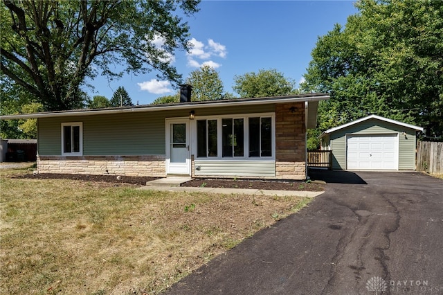 single story home with an outbuilding, a front lawn, and a garage