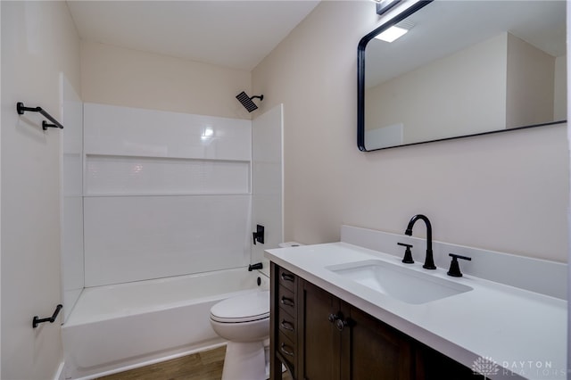 full bathroom with toilet, vanity,  shower combination, and hardwood / wood-style flooring