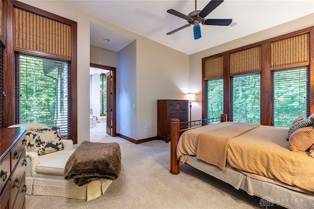 bedroom featuring multiple windows, ceiling fan, and light colored carpet