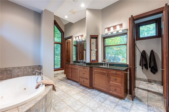 bathroom featuring vanity and tiled tub