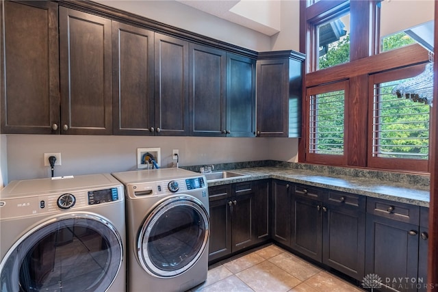 washroom featuring light tile patterned flooring, cabinets, sink, and washing machine and clothes dryer