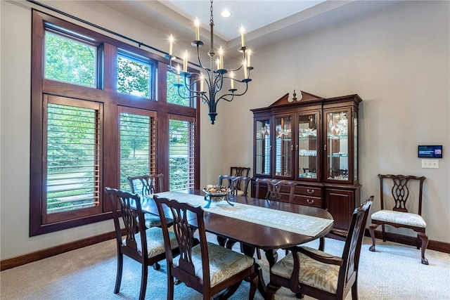 dining area with light colored carpet and a notable chandelier