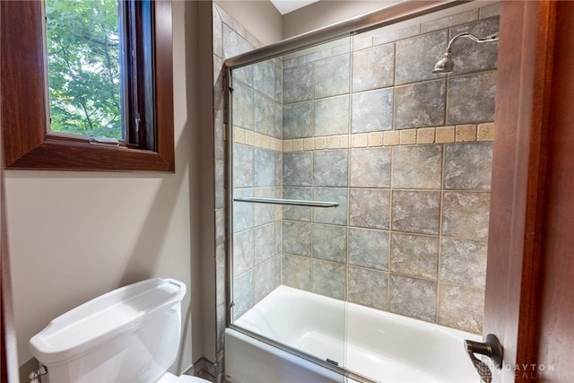 bathroom featuring shower / bath combination with glass door and toilet