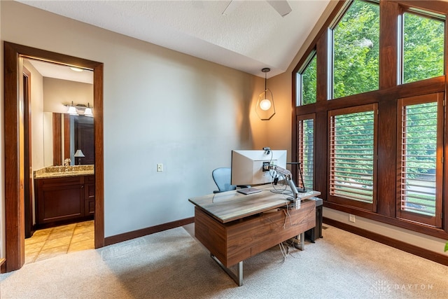 carpeted home office featuring a textured ceiling, lofted ceiling, sink, and a wealth of natural light