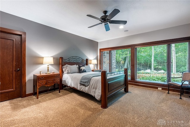 carpeted bedroom with multiple windows and ceiling fan