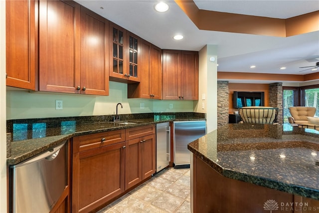 kitchen with ceiling fan, dark stone countertops, sink, and stainless steel appliances