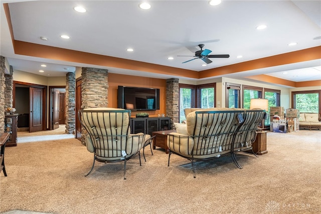 carpeted living room featuring decorative columns and ceiling fan