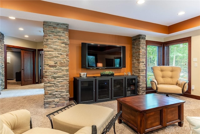 carpeted living room featuring indoor bar and ornate columns