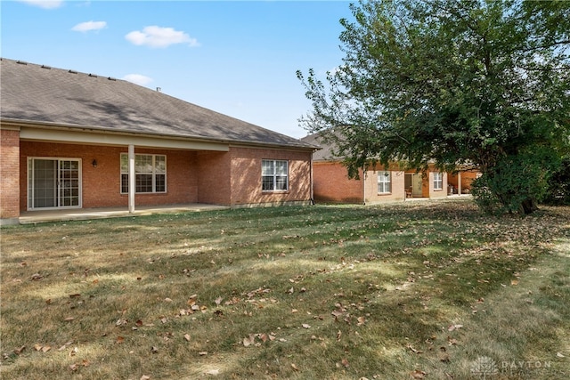 back of property featuring a patio area and a yard