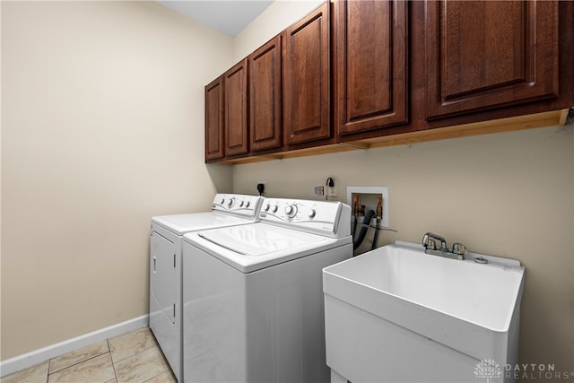 laundry area with independent washer and dryer, cabinets, sink, and light tile patterned floors