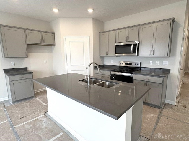 kitchen with gray cabinets, sink, stainless steel appliances, and a kitchen island with sink