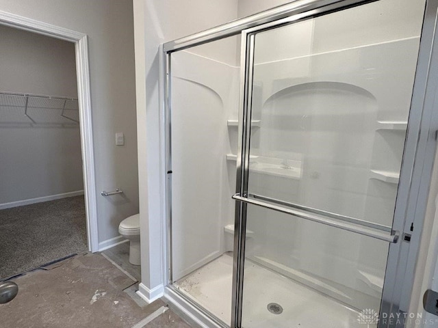 bathroom featuring toilet, concrete flooring, and walk in shower