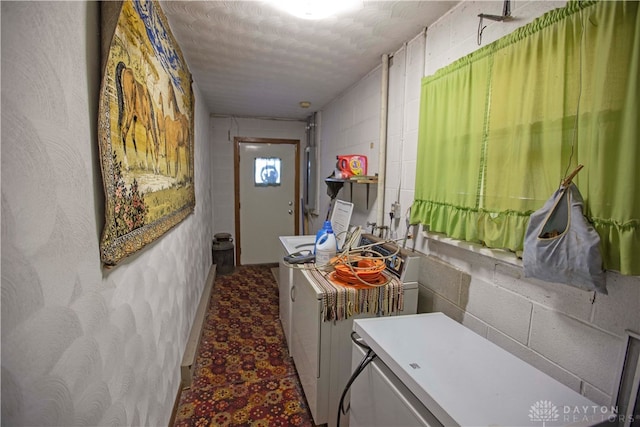 laundry area featuring washing machine and clothes dryer and a textured ceiling