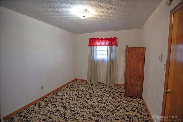 unfurnished room featuring a textured ceiling and carpet flooring