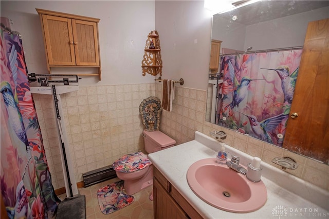 bathroom with tile walls, curtained shower, vanity, a baseboard radiator, and toilet