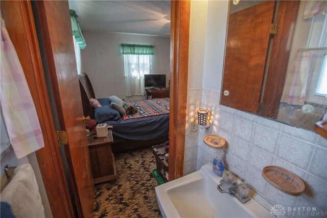 bathroom featuring backsplash, sink, and a healthy amount of sunlight