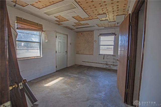 unfurnished room featuring concrete floors and a healthy amount of sunlight