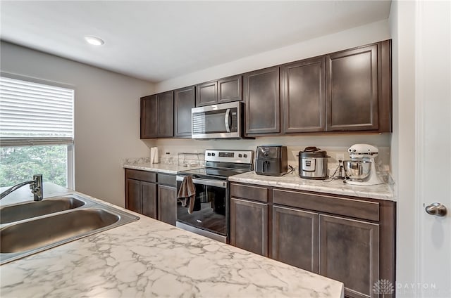 kitchen featuring dark brown cabinetry, sink, and appliances with stainless steel finishes