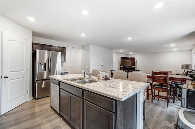 kitchen featuring light hardwood / wood-style flooring, sink, an island with sink, and stainless steel appliances