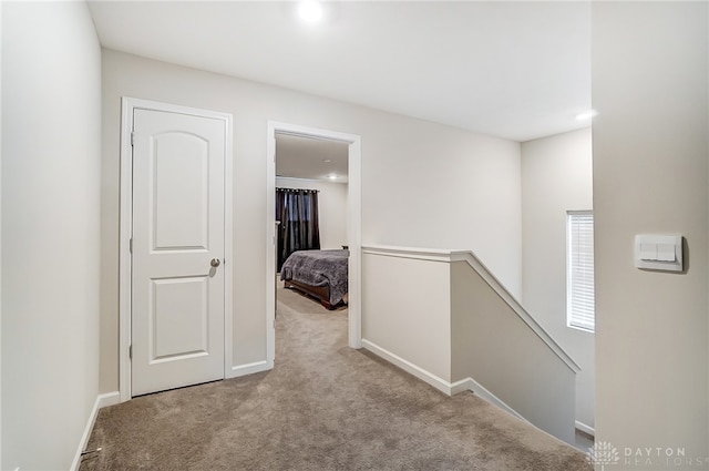 hall with light colored carpet