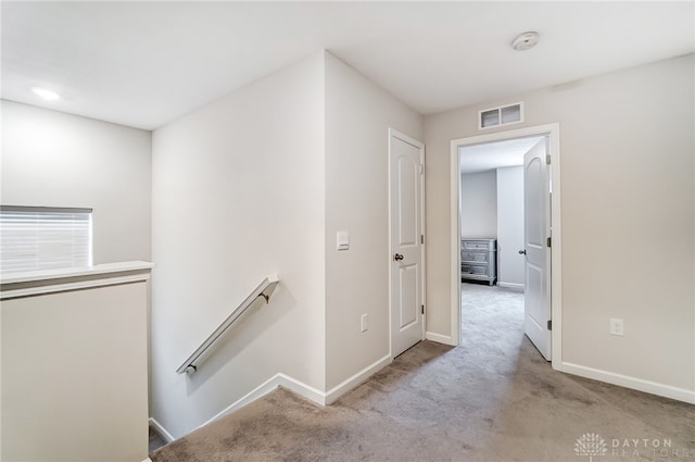 corridor featuring light colored carpet