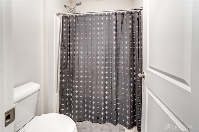 bathroom featuring a shower with shower curtain and toilet