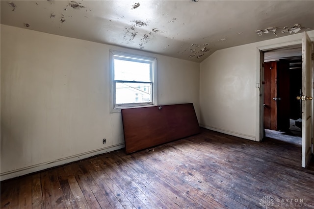 unfurnished room featuring vaulted ceiling and dark hardwood / wood-style floors