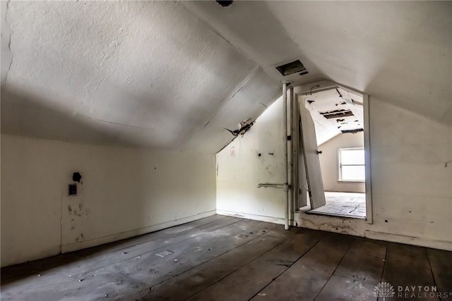 bonus room with lofted ceiling and a textured ceiling