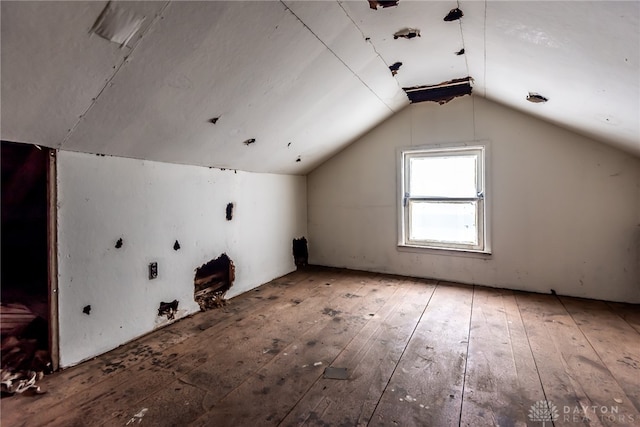 additional living space with lofted ceiling and hardwood / wood-style flooring