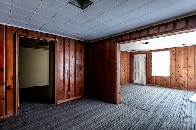 unfurnished room featuring wood walls