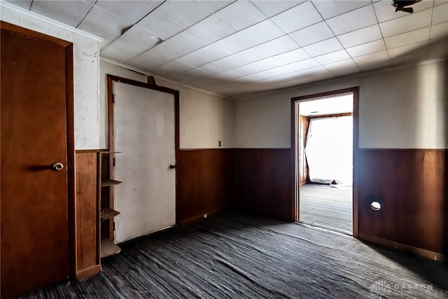 carpeted empty room with wooden walls