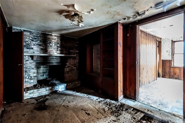 interior space with wood walls and a brick fireplace