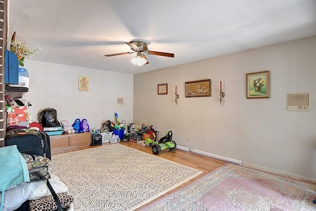 recreation room with baseboards, a ceiling fan, and wood finished floors