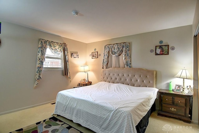 bedroom featuring light carpet and baseboards