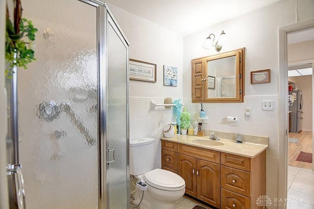 bathroom featuring toilet, a shower stall, tile walls, and tile patterned floors