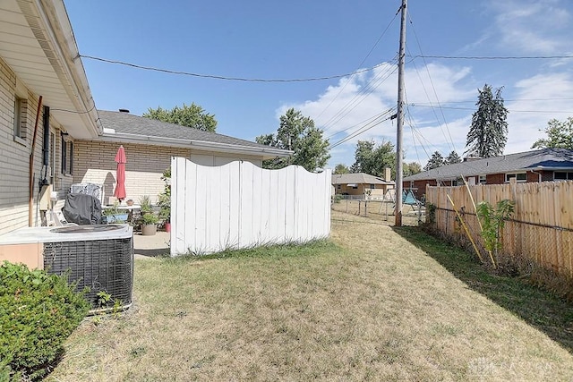 view of yard featuring fence and central AC unit