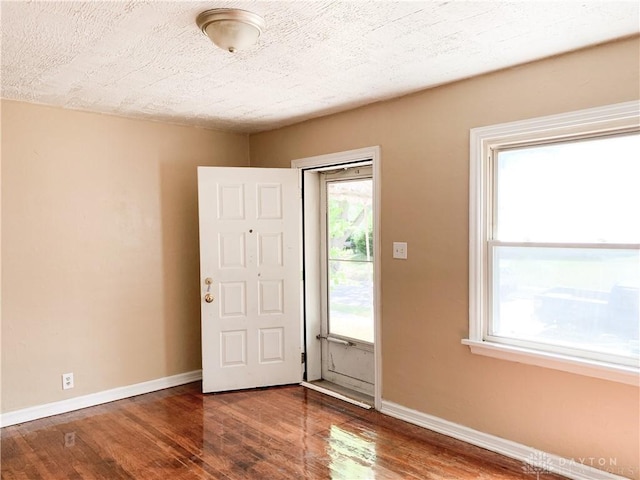 foyer featuring wood-type flooring and a textured ceiling