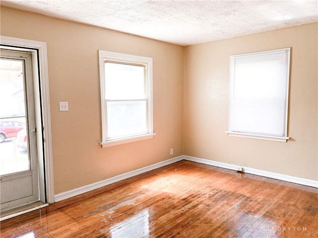 spare room featuring hardwood / wood-style flooring and a textured ceiling