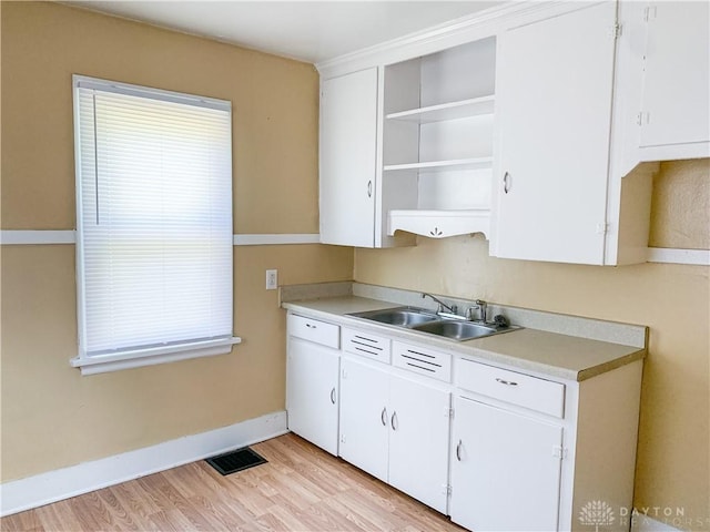 kitchen featuring white cabinetry, sink, dishwasher, and light hardwood / wood-style flooring