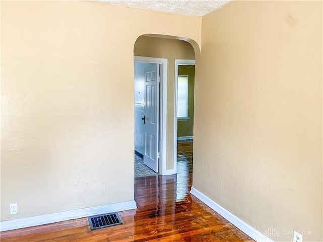 hall featuring dark hardwood / wood-style flooring and a textured ceiling