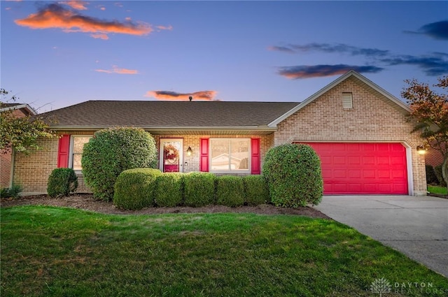 single story home with a garage and a yard