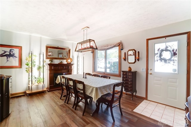 dining space with hardwood / wood-style floors and a textured ceiling