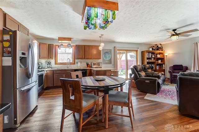 dining area featuring ceiling fan, dark hardwood / wood-style flooring, a healthy amount of sunlight, and a textured ceiling