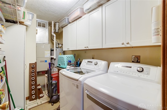 laundry area with separate washer and dryer, cabinets, and a textured ceiling